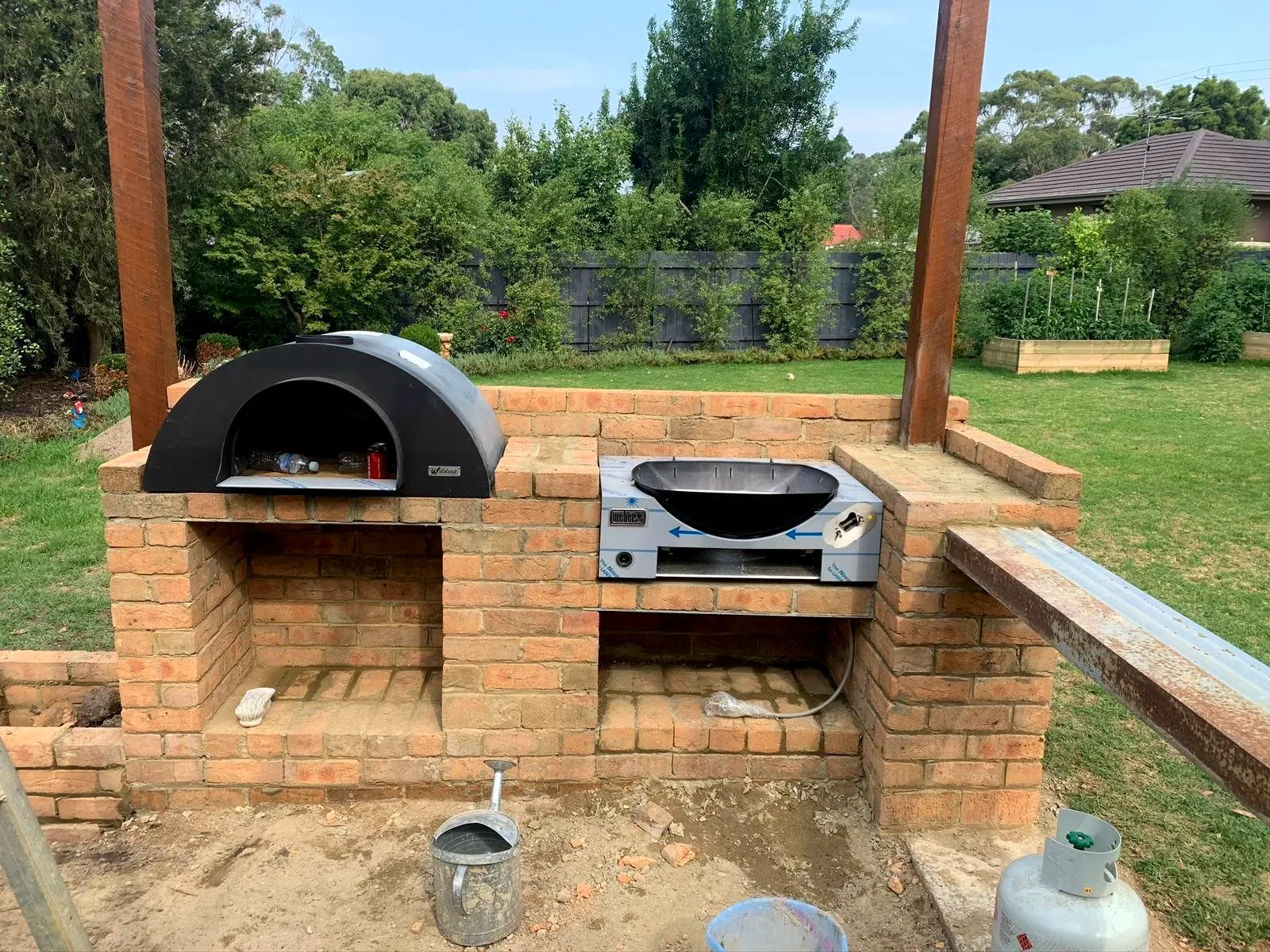 Brick outdoor kitchen with pizza oven and BBQ bay